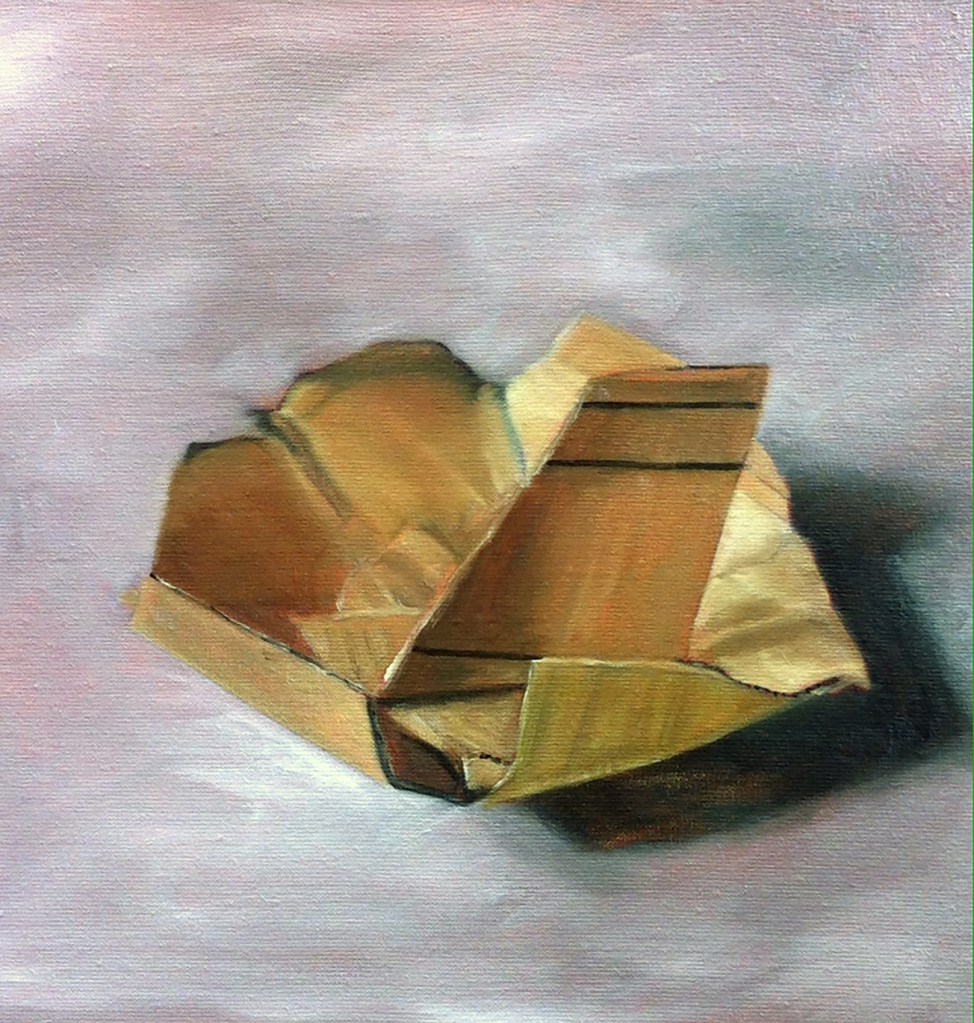 A crumpled cardboard box sitting on a flat surface, with soft lighting and a neutral background.